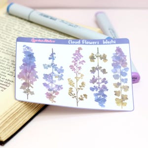 Könnte beinhalten: Ein Stickerbogen mit dem Text "Cloud Flowers Washi" mit Aquarellillustrationen von Blumenstielen in Lila-, Blau- und Goldtönen. Der Stickerbogen ist rechteckig mit abgerundeten Ecken.