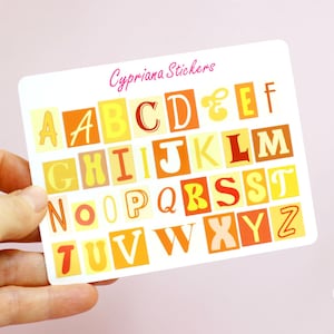 Könnte beinhalten: Eine Bogen mit Alphabet-Aufklebern im Retro-Design. Die Buchstaben sind in verschiedenen Farben, darunter Gelb, Orange und Rot. Die Aufkleber sind in alphabetischer Reihenfolge angeordnet. Der Bogen ist mit "Cypriana Stickers" beschriftet.