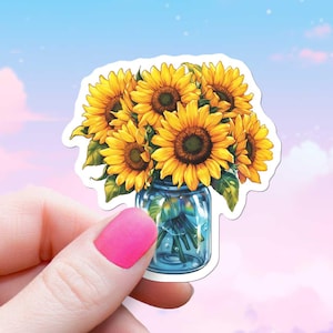 Op de afbeelding: Een sticker met een boeket gele zonnebloemen in een blauwe glazen pot. De zonnebloemen zijn in een vaas op een witte achtergrond gerangschikt.