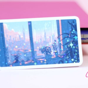 May include: A sticker featuring a window view of a city skyline with a blue and pink color scheme. The sticker has a holographic finish with glitter stars.