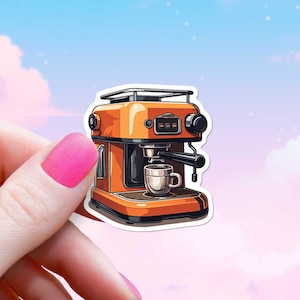 May include: A sticker featuring an orange espresso machine with a small white coffee cup. The machine has black accents and a silver top. The sticker is held by a hand with pink nail polish against a pastel sky background.