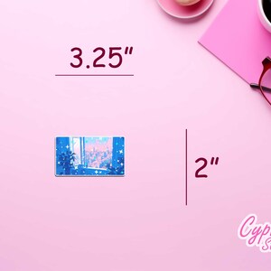 Puede incluir: Una pegatina de ciudad con un cielo azul y rosa y estrellas. La pegatina mide 3,25 pulgadas de ancho y 2 pulgadas de alto. La pegatina est&aacute; sobre un fondo rosa.
