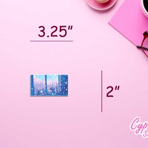 May include: A blue and white sticker with a cityscape and stars. The sticker is 3.25 inches wide and 2 inches tall. The sticker is on a pink background.