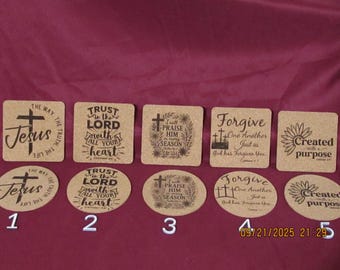 May include: Five cork coasters with religious quotes and imagery. The coasters feature phrases like "Jesus," "Trust in the Lord," and "Forgive." The designs include crosses and floral elements. The coasters are in square and oval shapes.