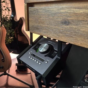 May include: A silver and black audio interface with a large knob and multiple buttons. The text "apollo twin" is printed on the device.