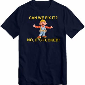 Peut inclure: T-shirt bleu marine avec un dessin animé d'un ouvrier du bâtiment et le texte "CAN WE FIX IT? NO, IT'S FUCKED!" en jaune. L'ouvrier porte un casque jaune, une chemise rouge, une salopette bleue et a les bras tendus.