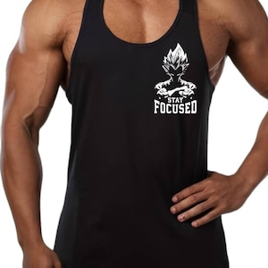 Puede incluir: Camiseta negra sin mangas con un gráfico blanco de un personaje de dibujos animados con el pelo de punta y el texto "STAY FOCUSED".