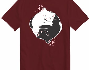 Puede incluir: Una camiseta de color granate con un gráfico de dos gatos en un diseño yin yang. Los gatos son blanco y negro y se abrazan. Hay pequeños corazones rosas alrededor de los gatos.