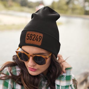 May include: Black beanie with a brown leather patch that says "58249" on it.