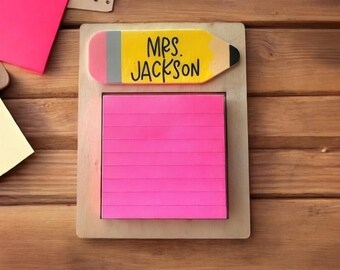 May include: A wooden desk organizer with a yellow pencil with the text "Mrs. Jackson" and a pink sticky note pad.