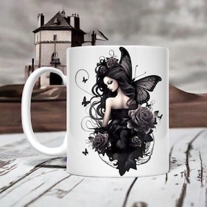 May include: White ceramic mug with a black and white illustration of a fairy with black wings and black roses. The fairy is wearing a black dress and has long black hair.