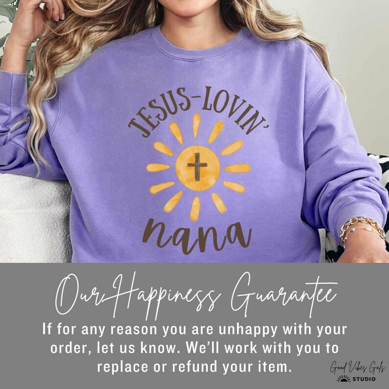 May include: A purple sweatshirt with the text "JESUS-LOVIN' nana" in a sunburst design. The sweatshirt has long sleeves and a crew neck. The text "Our Happiness Guarantee" is below the sweatshirt.
