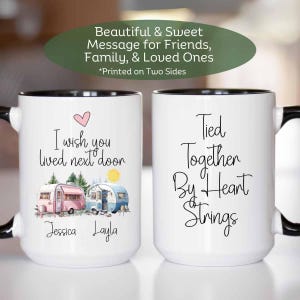 May include: Two white coffee mugs with black handles and black rims. One mug features a pink and blue camper van illustration with the text "I wish you lived next door" and the names "Jessica" and "Layla". The other mug features the text "Tied Together By Heart Strings".