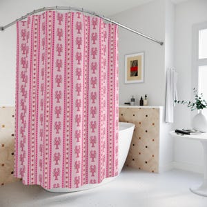 May include: A pink shower curtain featuring a repeating pattern of pink lobsters, stars, and stripes. The curtain hangs in front of a white bathtub in a bathroom. The curtain is made of a soft, durable material, suitable for a bathroom.