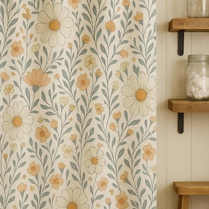 May include: A floral shower curtain with a cream background and a pattern of large white daisies with yellow centers and smaller orange flowers. The curtain is hanging in a bathroom with wooden shelves and a small wooden stool.