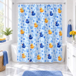 May include: A shower curtain featuring a repeating pattern of yellow rubber ducks and dark blue rubber ducks interspersed with light blue bubbles of varying sizes against a white background, suspended from a silver metal rod with rings.