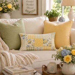 Pu&ograve; includere: Un cuscino rettangolare con un design patchwork di motivi floreali gialli e verdi, quadretti vichy e stampe damascate. Il cuscino &egrave; posizionato su un divano color crema tra un cuscino quadrato verde salvia e un cuscino quadrato giallo.