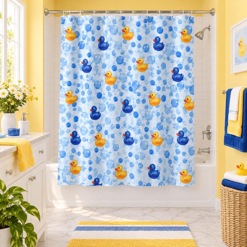 May include: A white shower curtain featuring a repeating pattern of yellow and blue rubber ducks interspersed with light and dark blue circular bubbles. The curtain hangs from a silver rod with rings, covering a white bathtub in a bathroom.