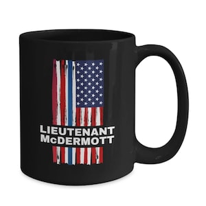 May include: Black ceramic coffee mug with a distressed American flag design and the text "Lieutenant McDermott" in white.