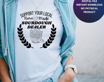 May include: White t-shirt with black text that reads "Support Your Local Home Made Sourdough Dealer". The text is surrounded by a wreath of leaves.