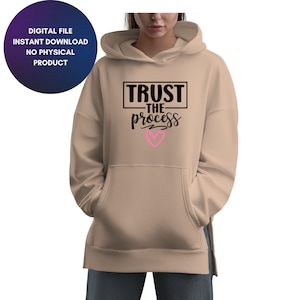 May include: A tan hoodie with a black graphic that says "TRUST THE PROCESS" with a pink heart underneath.