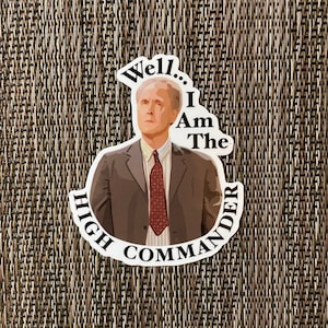 May include: A white sticker with a cartoon image of a man in a suit and tie. The text on the sticker reads "Well... I Am The High Commander".