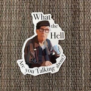 May include: A sticker featuring a cartoon illustration of an older man with glasses and a hat, holding a cup. The text on the sticker reads "What the Hell Are You Talking About?"