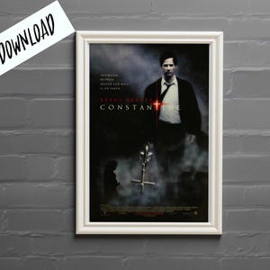 May include: A framed movie poster for the film "Constantine" featuring Keanu Reeves. The poster has a white frame and is set against a gray brick wall. The words "DIGITAL DOWNLOAD" are in a white rectangle in the upper left corner.