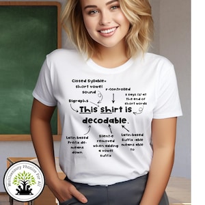 May include: White t-shirt with black text explaining phonics concepts. The shirt features phrases like "Closed Syllable," "Digraphs," and "This shirt is decodable." A logo for "Multisensory Phonics For All" is visible.