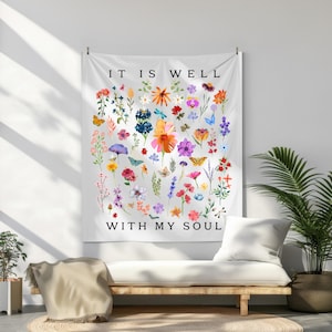May include: White tapestry featuring a floral design and the text "It is well with my soul". The flowers are in shades of pink, purple, red, yellow, and blue. There are also butterflies and dragonflies.