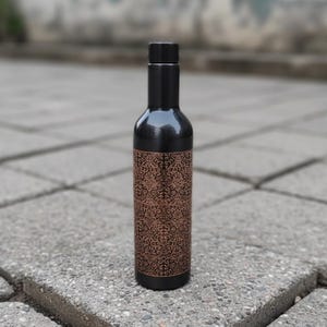 Handmade pure copper water bottle with polished finish and engraved detailing, Ayurvedic wellness drinkware ideal for yoga lifestyle and eco friendly reusable hydration.