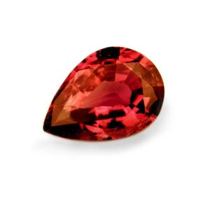 May include: A pear-shaped red gemstone with a slight orange hue.