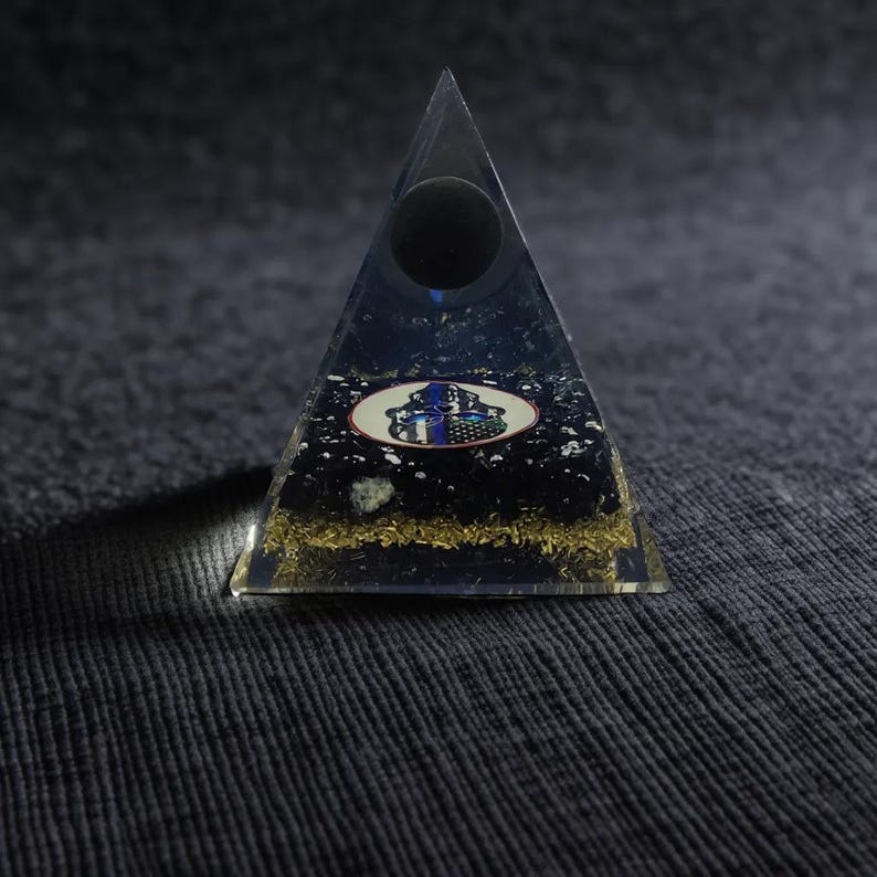 Healing crystal pyramid with gold flakes and resin layers