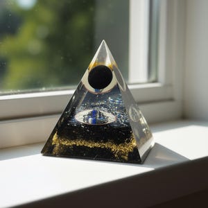 Black tourmaline orgone pyramid placed on hand close-up