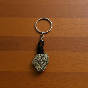 raw pyrite crystal keychain on marble background