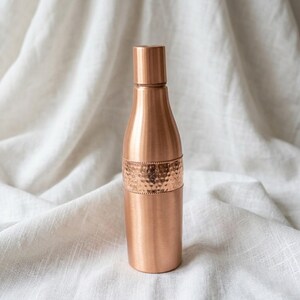 Traditional copper water storage bottle for detox routine, handcrafted Indian copper vessel for daily hydration.