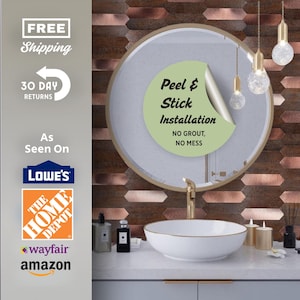 May include: A bathroom vanity featuring a white vessel sink with a gold rim, a round mirror, and a wall covered in horizontal, metallic copper-toned tiles. A light green circular sticker on the mirror reads: Peel & Stick Installation, NO GROUT, NO MESS.