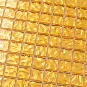 May include: A close-up of a sheet of gold mosaic tiles. The tiles are small and square, and they have a slightly rippled surface. The tiles are arranged in a grid pattern.