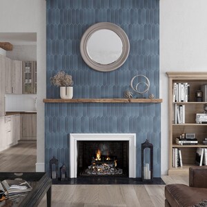 May include: A fireplace with a blue tile surround and a wooden mantel. The fireplace has a white surround and a black firebox with a fire burning inside. There is a round mirror above the mantel.
