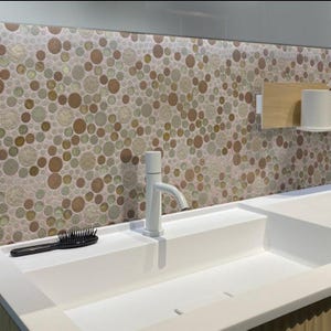 May include: A white porcelain sink with a single faucet and a hairbrush on the counter. The backsplash is made of small, round, iridescent tiles in shades of brown, beige, and pink.