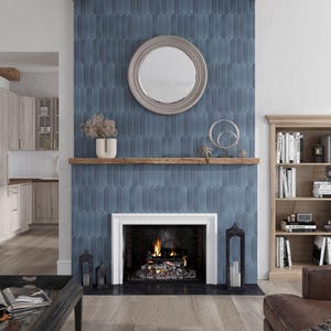 May include: A fireplace with a blue tile surround and a wooden mantel. The fireplace has a white surround and a black firebox with a fire burning inside. There is a round mirror above the mantel.