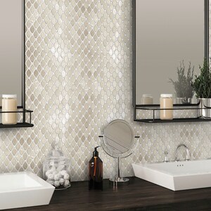 May include: A bathroom with two white sinks and a mirror above each sink. The walls are covered in a beige and white mosaic tile with a diamond pattern. There are two jars of soap on the counter and a round mirror on a stand.