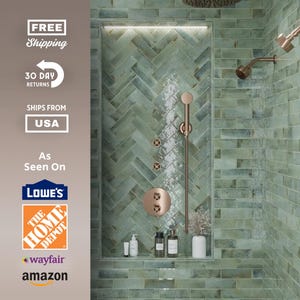 May include: A modern shower design featuring green herringbone tile and bronze fixtures. The shower includes a rain shower head, handheld shower, and built-in shelf with toiletries. The design is clean and contemporary.