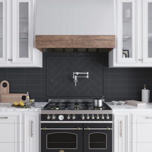 May include: Black and stainless steel range with a wood hood above it. The range has a black oven with a glass door and a gas cooktop with six burners. The hood is made of wood and has a black metal frame. The backsplash is black tile with a herringbone pattern.