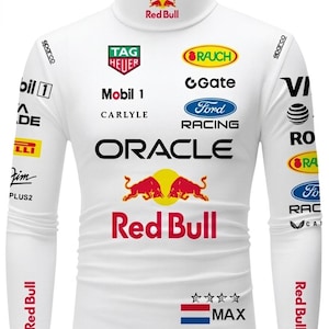 Puede incluir: Camiseta blanca de cuello alto con múltiples logotipos de patrocinadores, incluyendo Red Bull, Oracle y Ford Racing. La camiseta presenta un logotipo de Red Bull en el cuello y las mangas, con la palabra "MAX" y un diseño de bandera en la parte inferior.