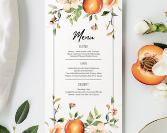May include: A peach-themed wedding menu with a floral design. The menu lists the entree, main course, and dessert options. The entree is seared lemon butter garlic scallops, the main course is risotto porcini with mixed mushroom, spinach and parmesan, and the dessert is wedding cake.