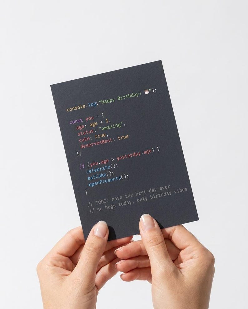 K&ouml;nnte beinhalten: Eine rechteckige schwarze Gru&szlig;karte mit farbigem Programmiercode-Text, der lautet: console.log("Happy Birthday! 🎂"); const you = { age: age + 1, status: "amazing", cake: true, deservesBest: true }; if (you.age > yesterday.age) { celebrate(); eatCake(); openPresents(); } // TODO: have the best day ever // no bugs today, only birthday vibes