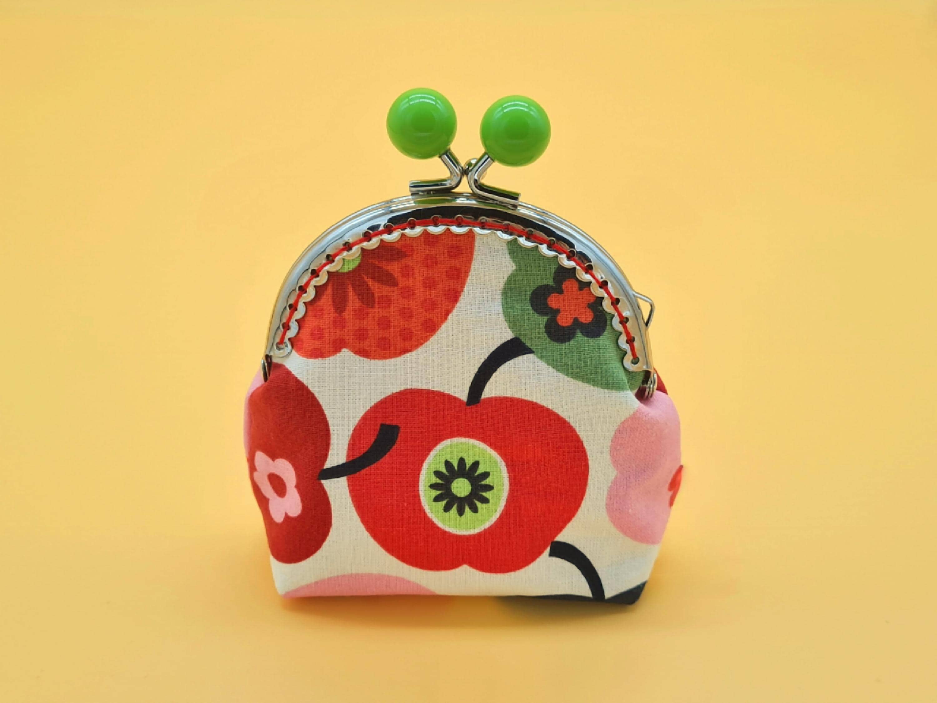 Small clip wallet made of cream-white cotton with apple motifs and metal frame