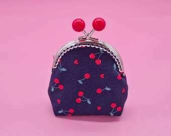 Small clip wallet made of dark blue cotton with cherries and metal frame