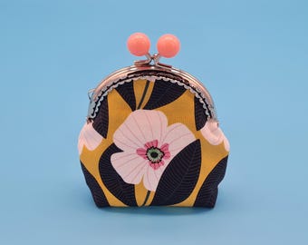 Small clip purse made of mustard yellow cotton with flower motif and metal frame